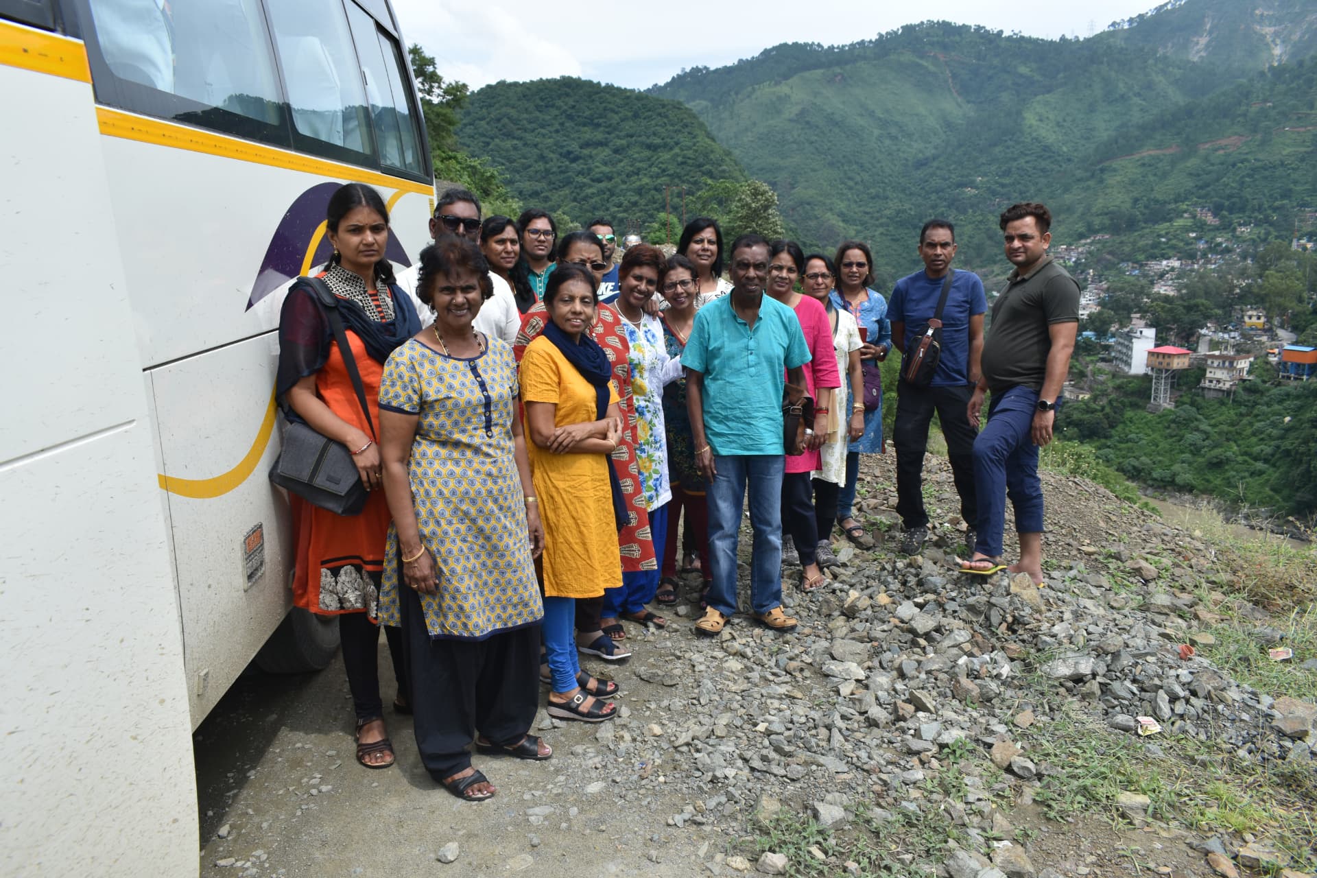 Tour group beside their coach on a green hill road during a pilgrimage
